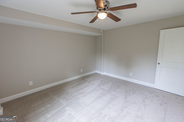 empty room featuring ceiling fan and light carpet