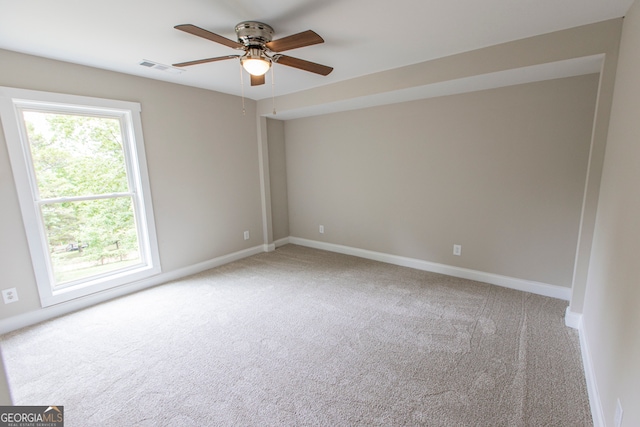 carpeted spare room with a wealth of natural light and ceiling fan