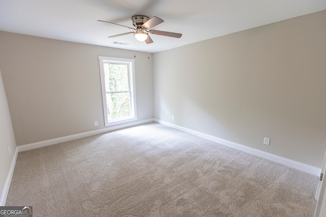 carpeted spare room featuring ceiling fan