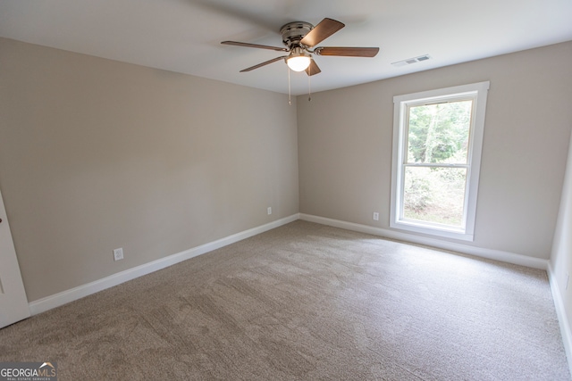 carpeted spare room with ceiling fan