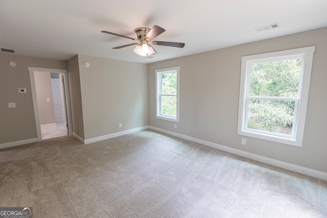 empty room featuring ceiling fan and light carpet