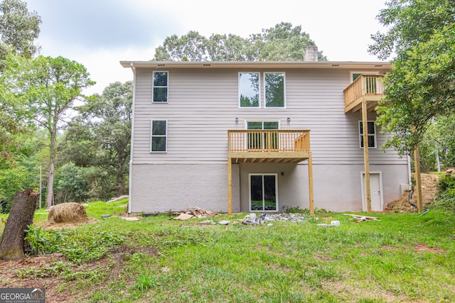 rear view of property featuring a balcony and a lawn