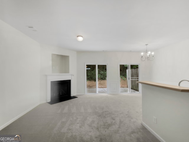 unfurnished living room featuring carpet and a notable chandelier