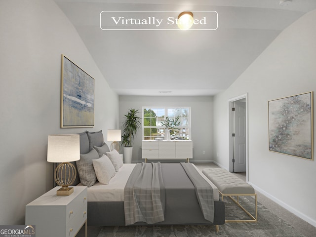 bedroom with lofted ceiling and dark colored carpet