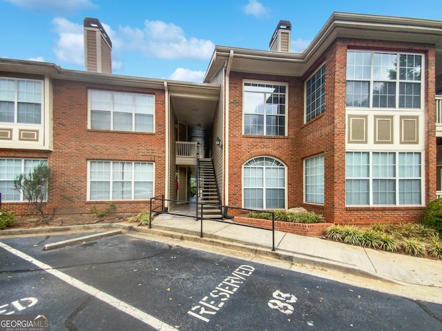 view of property featuring uncovered parking and stairway