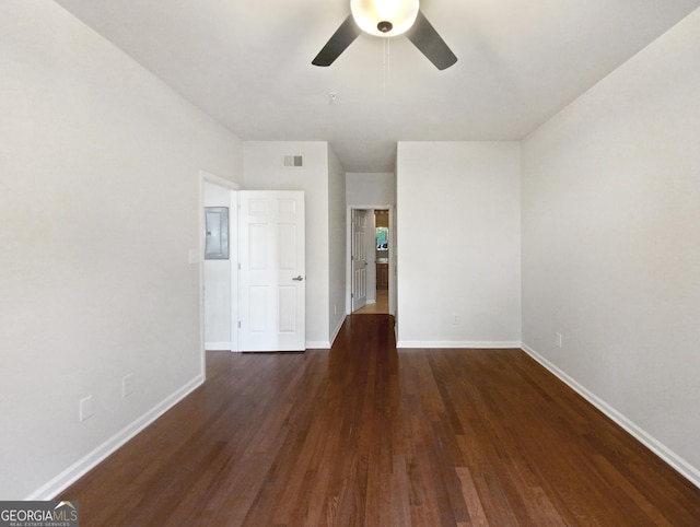 unfurnished bedroom featuring electric panel, baseboards, visible vents, a ceiling fan, and dark wood-type flooring