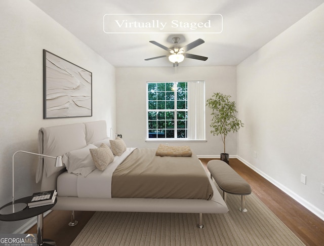 bedroom with ceiling fan, wood finished floors, and baseboards