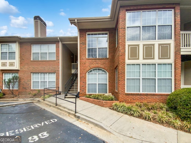 view of property featuring uncovered parking and stairway