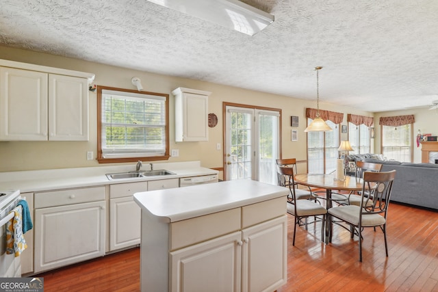 kitchen with white cabinets, wood-type flooring, and a wealth of natural light