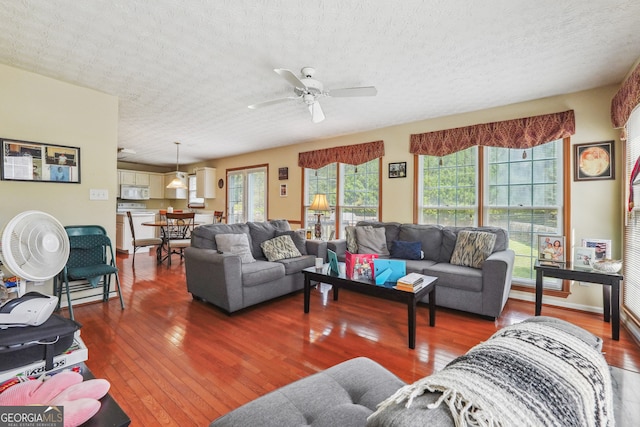 living room featuring ceiling fan, hardwood / wood-style flooring, and a healthy amount of sunlight