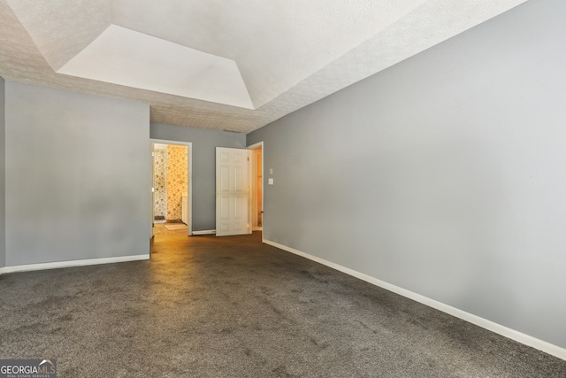 unfurnished room featuring a raised ceiling and a textured ceiling