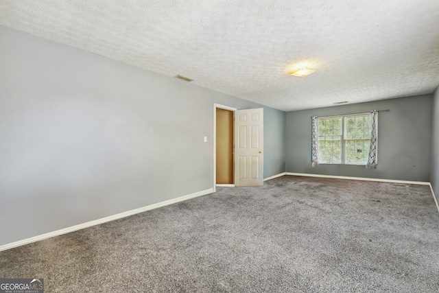 carpeted empty room featuring a textured ceiling