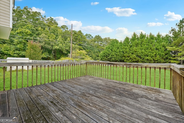 wooden terrace featuring a lawn