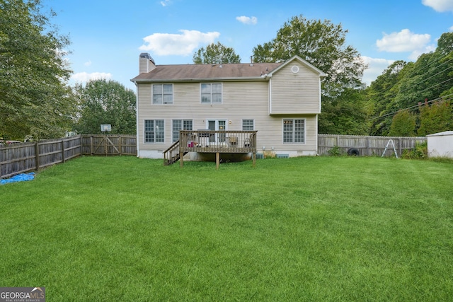 rear view of property featuring a yard and a deck