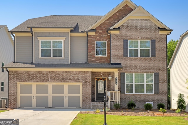 craftsman-style house with central AC unit, a front yard, and a garage