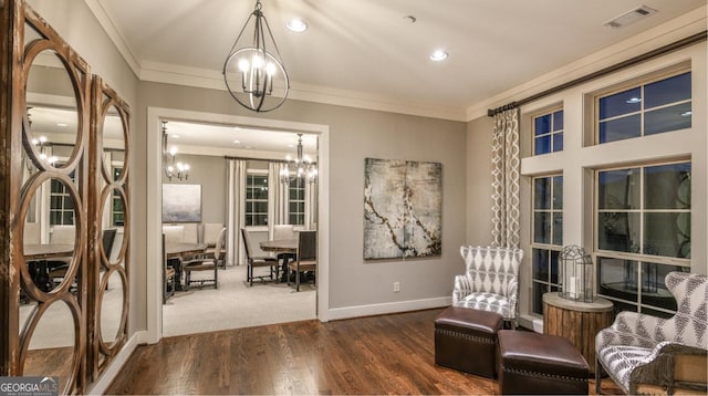 living area with ornamental molding, a chandelier, and dark hardwood / wood-style flooring