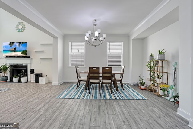 dining room with a chandelier, light hardwood / wood-style floors, and crown molding