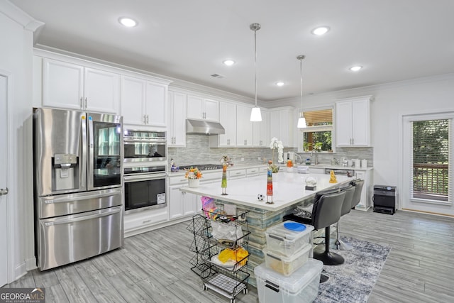 kitchen featuring stainless steel appliances, white cabinetry, and plenty of natural light