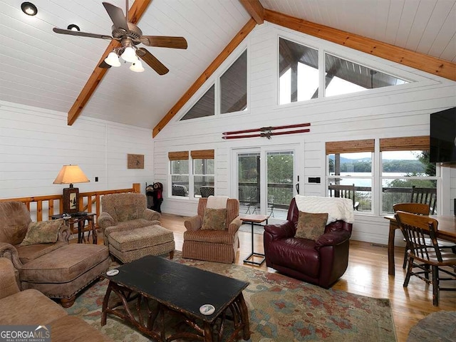 living room with wood walls, beamed ceiling, high vaulted ceiling, hardwood / wood-style flooring, and ceiling fan