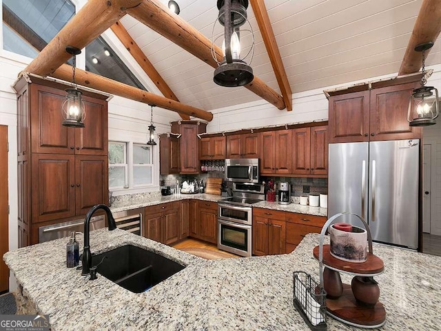 kitchen featuring decorative light fixtures, appliances with stainless steel finishes, tasteful backsplash, sink, and light stone counters