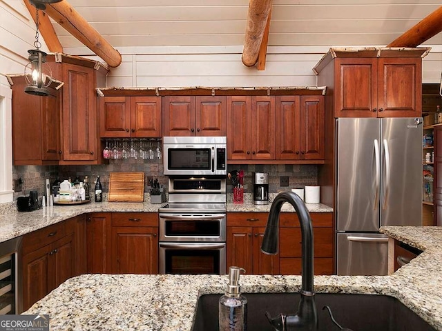 kitchen with light stone counters, stainless steel appliances, sink, decorative backsplash, and beam ceiling