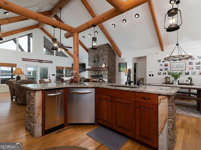 kitchen with light hardwood / wood-style flooring, high vaulted ceiling, and stainless steel dishwasher