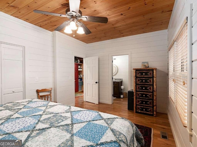 bedroom with wood ceiling, wood walls, ceiling fan, and light hardwood / wood-style floors