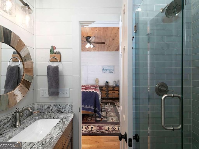 bathroom with vanity, wood-type flooring, walk in shower, wood ceiling, and ceiling fan