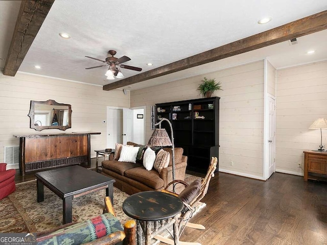 living room with dark wood-type flooring, ceiling fan, wooden walls, and beam ceiling