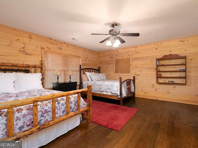 bedroom featuring dark wood-type flooring, ceiling fan, and wooden walls