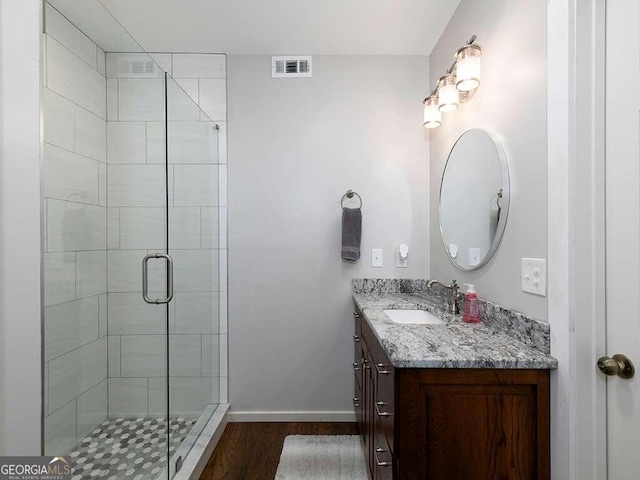 bathroom with walk in shower, hardwood / wood-style flooring, and vanity