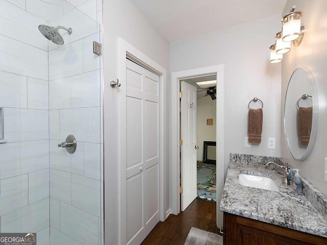 bathroom featuring vanity, a tile shower, and hardwood / wood-style flooring