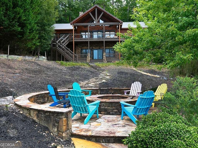 back of house featuring a deck, a patio, and an outdoor fire pit