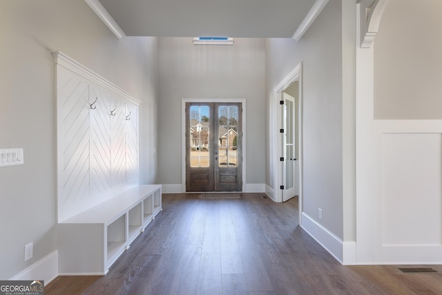 mudroom with crown molding and dark wood-type flooring