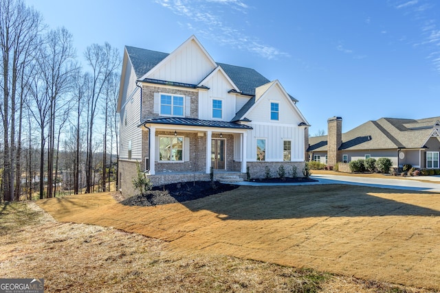 modern farmhouse style home with covered porch and a front lawn