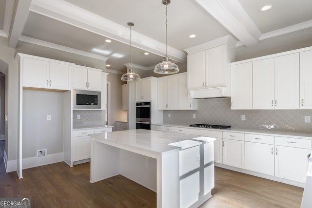 kitchen with a kitchen island, pendant lighting, white cabinetry, light stone countertops, and beam ceiling