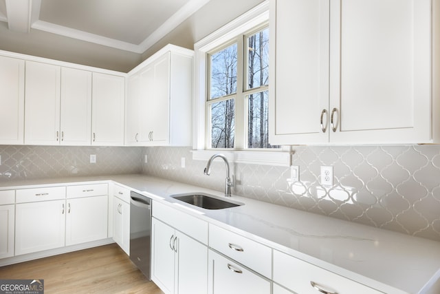 kitchen featuring sink, white cabinetry, tasteful backsplash, stainless steel dishwasher, and light stone countertops