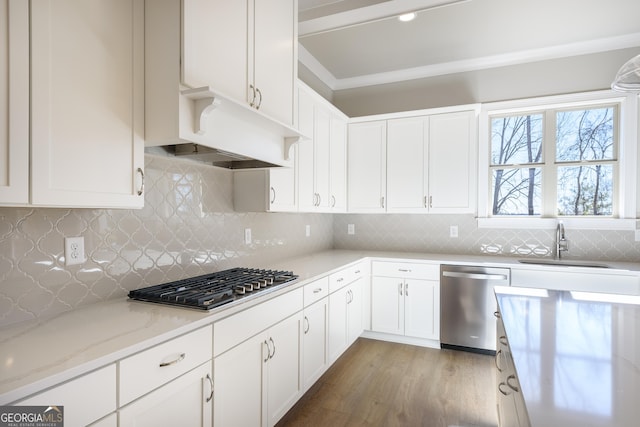 kitchen featuring sink, backsplash, stainless steel appliances, and white cabinets