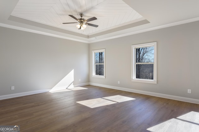 spare room with plenty of natural light, dark hardwood / wood-style floors, ceiling fan, and a tray ceiling