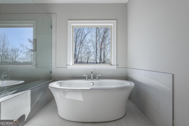 bathroom featuring a tub to relax in and a wealth of natural light