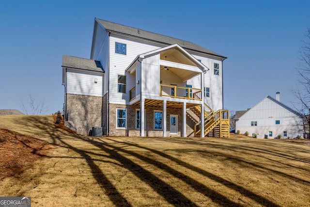 rear view of property featuring a lawn, a balcony, and ceiling fan