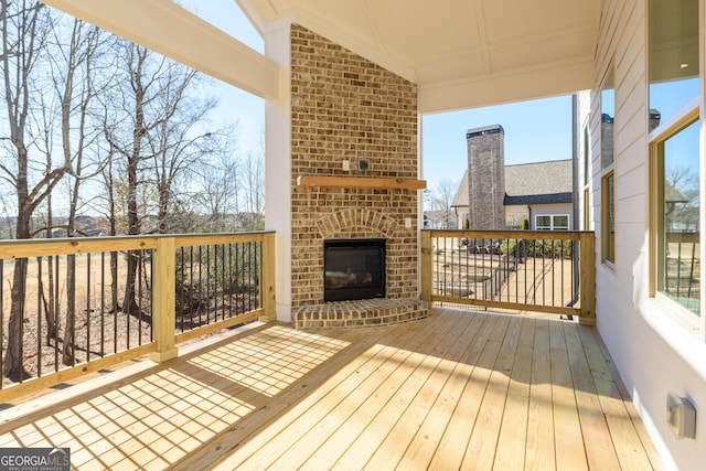 wooden terrace with an outdoor brick fireplace