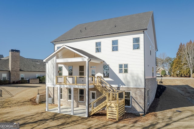 back of house featuring a balcony and a patio area