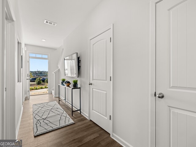 corridor with dark hardwood / wood-style flooring