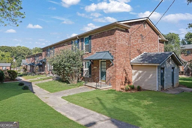 view of front of home with a storage unit and a front yard