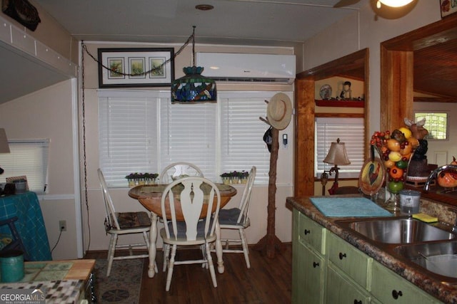 dining area with dark wood-type flooring, sink, and a wall mounted air conditioner