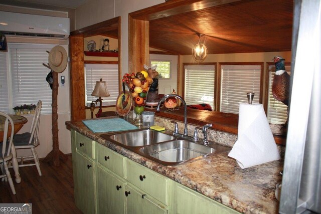 kitchen with a wall mounted AC, dark hardwood / wood-style floors, decorative light fixtures, sink, and green cabinetry