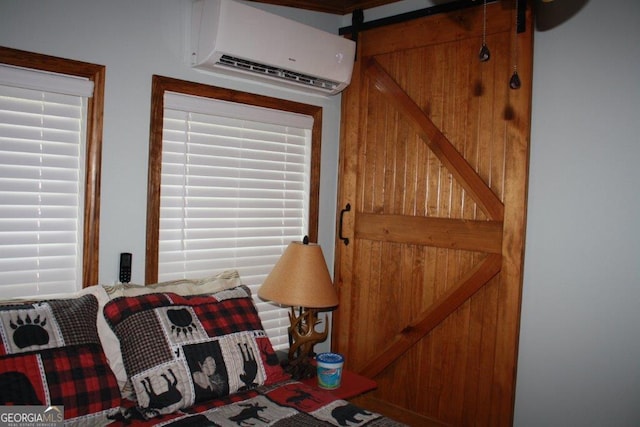 bedroom with a barn door, a wall mounted AC, and multiple windows