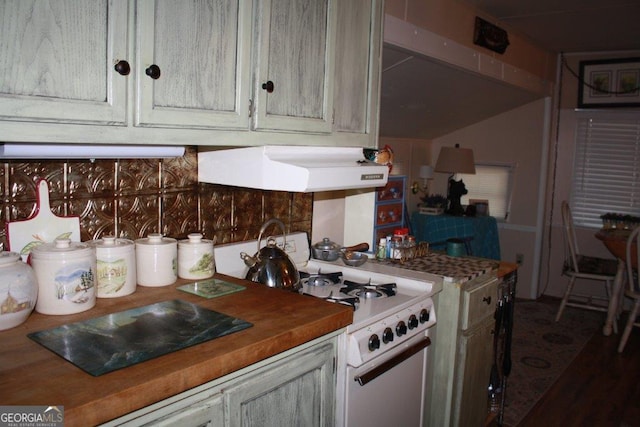 kitchen with backsplash, white gas stove, and butcher block counters