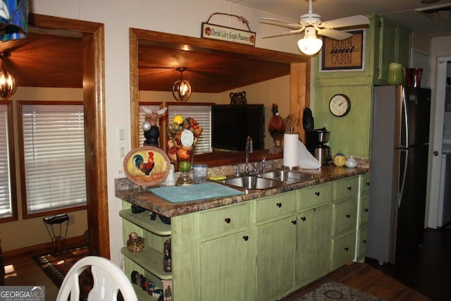 kitchen featuring hardwood / wood-style flooring, sink, stainless steel fridge, and green cabinetry